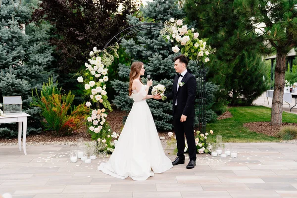 Bröllop ceremoni i båge av levande blommor. brud säger bröllop löfte och gråta — Stockfoto
