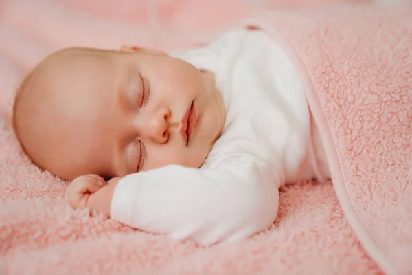 Slapende baby onder de roze deken. gezonde slaap bij pasgeborenen. — Stockfoto