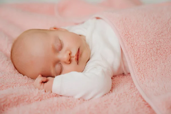 Slapende baby onder de roze deken. gezonde slaap bij pasgeborenen. — Stockfoto