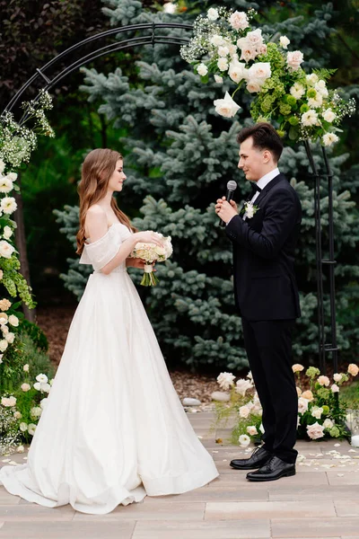 Esküvői szertartás boltíves virágok.menyasszony hallgat vőlegény fogadalom és sírás. — Stock Fotó