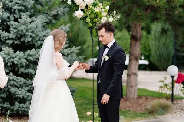 Cerimonia nuziale all'aperto in un arco di fiori viventi.sposi scambiati anelli — Foto Stock