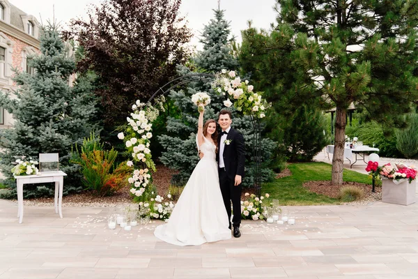 Cérémonie de mariage en plein air dans une arche de fleurs vivantes.Beau couple jeunes mariés — Photo