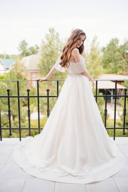 Dikiz aynası. Beyaz gelinlikli güzel bir kadın terasta duruyor.. 