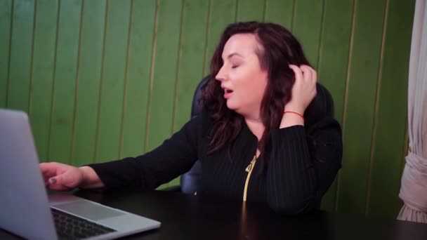 Una mujer con un escote se comunica en un video chat con un hombre y coquetea — Vídeos de Stock