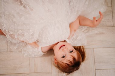 Yukarıdan bak. Beyaz elbiseli küçük bir kız yerde yatıyor.. 