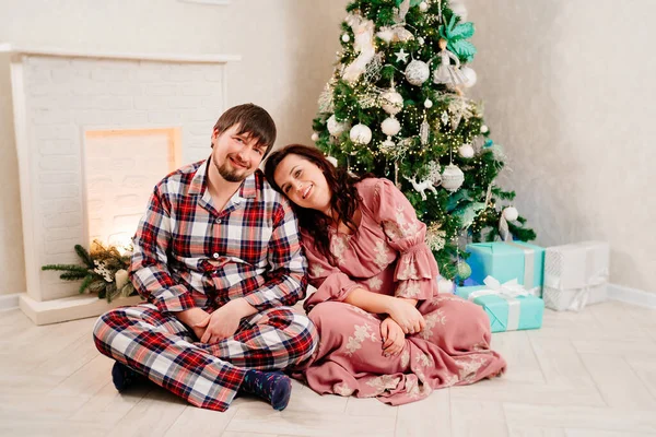 Feliz, pareja relajada en el suelo del árbol de Navidad en casa. —  Fotos de Stock