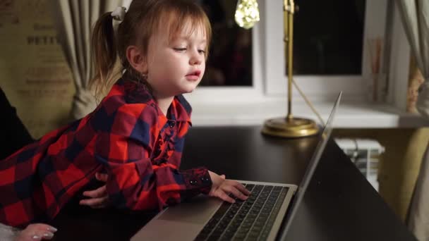 La petite fille empêche la mère pigiste de travailler sur l'ordinateur. — Video