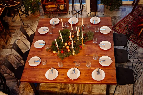 Pohled shora. Velký dřevěný stůl sloužil k vánoční večeři. Nedostatek světla. — Stock fotografie