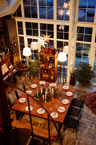 Vista desde arriba. Una gran mesa de madera servida para la cena de Navidad. Baja luz. — Foto de Stock