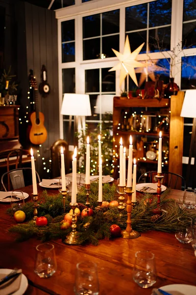 Gran mesa cuadrada de madera servida para la cena de Navidad. estilo retro. Baja luz. — Foto de Stock