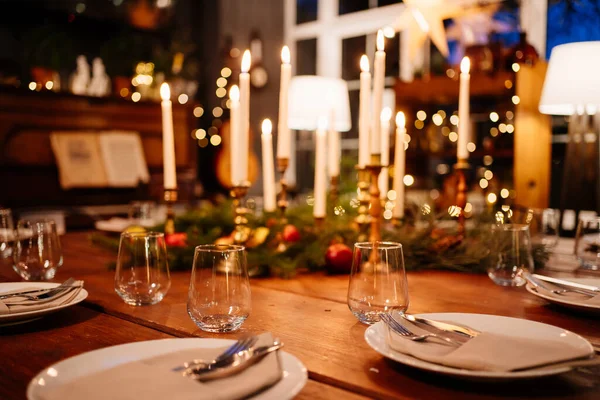 Gran mesa cuadrada de madera servida para la cena de Navidad. estilo retro. Baja luz. — Foto de Stock