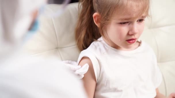 Маленька дівчинка плаче від болю і боїться. лікар дає ін'єкції. вакцинація . — стокове відео