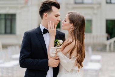 Güzel, nazik ve mutlu gelin ve damat. Kadın nazikçe erkeğin yüzüne dokunur.