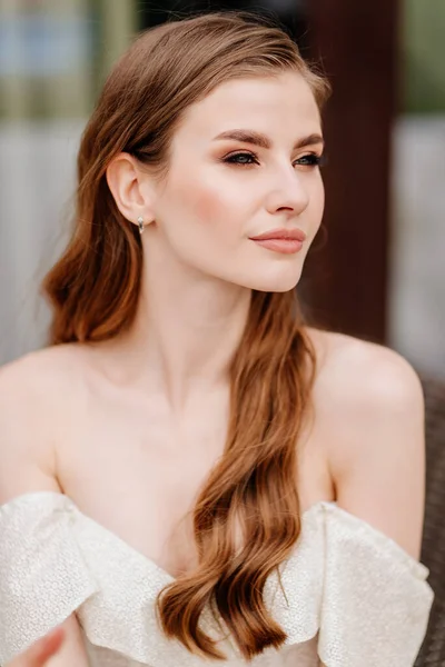 Retrato de mujer hermosa en vestido blanco con el pelo largo mirando a la distancia. — Foto de Stock