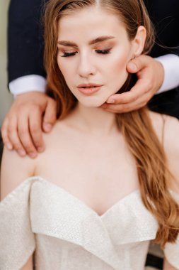 Damat elleri nazikçe güzel gelinin yüzüne dokunur.. 