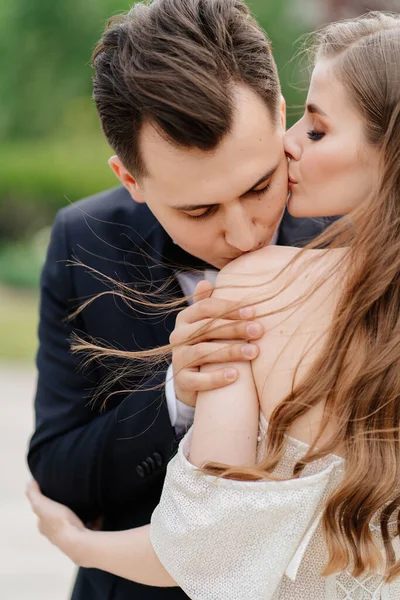 Sposa e sposo belli, gentili e felici. uomo bacia dolcemente le donne spalla — Foto Stock