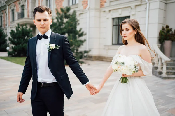 Der Bräutigam und die Braut gehen ins Freie. Erstes Treffen vor der Trauung — Stockfoto