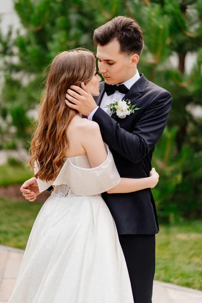 Sposa e sposo belli, gentili e felici. l'uomo tocca delicatamente il viso delle donne — Foto Stock