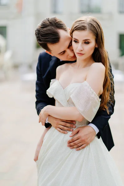 Bela, doce e feliz noiva e noivo. homem beija suavemente o rosto das mulheres — Fotografia de Stock