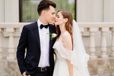 Güzel yeni evliler bir ışık binasının arka planında duruyorlar.. 