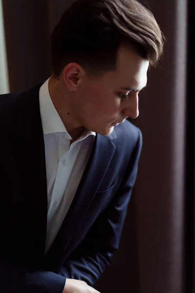 profile of person. young man in white shirt and a black jacket.