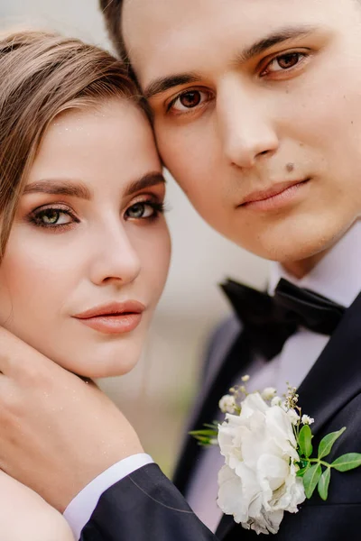 Sposa e sposo belli, gentili e felici. l'uomo tocca delicatamente il viso delle donne — Foto Stock