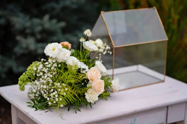Buquê de flores, caixa transparente para envelopes em uma mesa branca. casamento — Fotografia de Stock