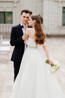 Güzel, nazik ve mutlu gelin ve damat. Kadın nazikçe erkeğin yüzüne dokunur.