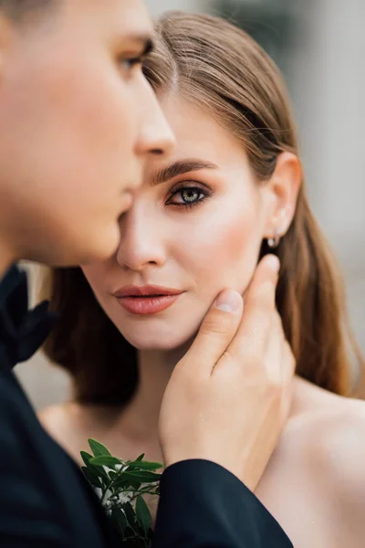 Novios hermosos, gentiles y felices. hombre suavemente toca la cara de las mujeres — Foto de Stock