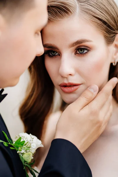 Novios hermosos, gentiles y felices. hombre suavemente toca la cara de las mujeres — Foto de Stock