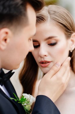 Güzel, nazik ve mutlu gelin ve damat. Erkek kadına nazikçe dokunur.