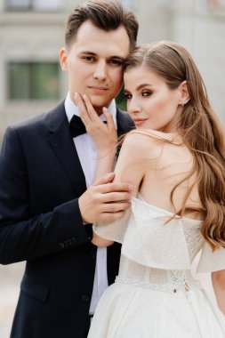 Güzel, nazik ve mutlu gelin ve damat. Kadın nazikçe erkeğin yüzüne dokunur.