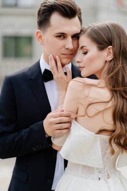 Güzel, nazik ve mutlu gelin ve damat. Kadın nazikçe erkeğin yüzüne dokunur.