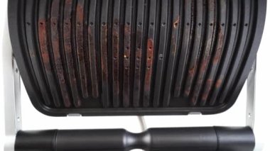 Elektrikli ızgarayı açık kapakla pişirdikten sonra kirlendi. yakın plan