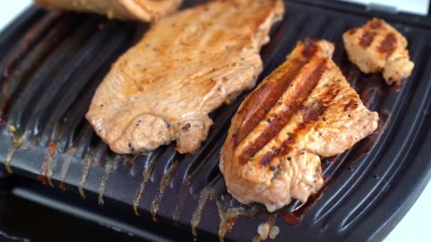 La carne se cocina en una parrilla eléctrica y se retira de la estufa. — Vídeo de stock
