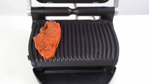 Un morceau de viande posé sur le gril électrique — Video