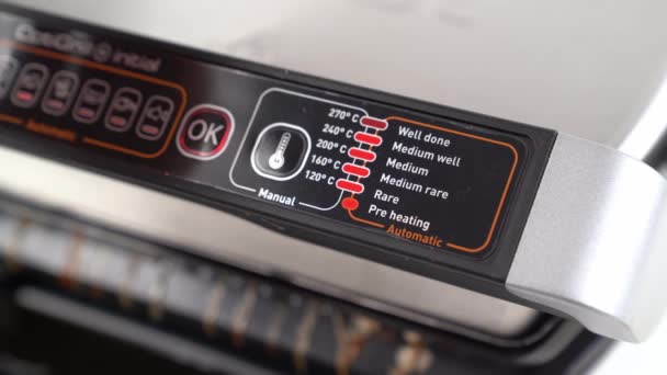 Middelmatig goed. Controlepaneel. vlees wordt gekookt op elektrische grill en open het deksel — Stockvideo