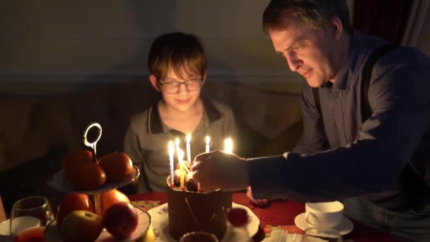 在黑暗中射击。爸爸点着蛋糕上的蜡烛. — 图库视频影像