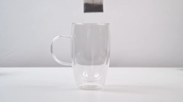 In einem großen Glasbecher mit doppeltem Glas mit heißem Wasser aufbrühen Teebeutel. — Stockvideo