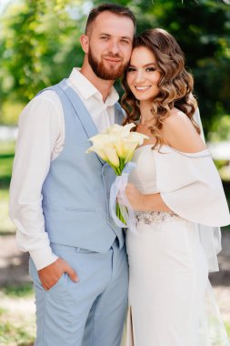 Mavi takım elbiseli damat ve zarif beyaz elbiseli gelin. 