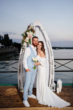 Rıhtımda suyun kenarında güzel bir düğün töreni. gelin ve damat.