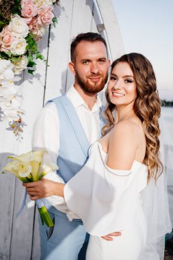 Rıhtımda suyun kenarında güzel bir düğün töreni. gelin ve damat.