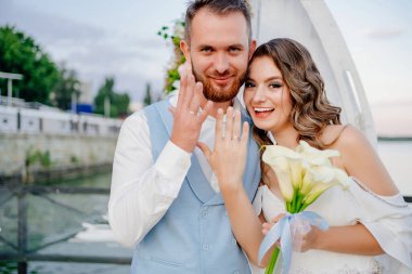 Mutlu yeni evliler yüzüklerini takıyorlar. Rıhtımda suyun kenarında güzel bir düğün töreni.. 