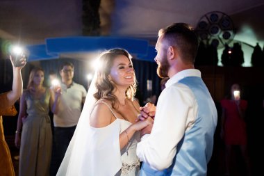 Düğün dansı. Gelin ve damat, şenlikli yemeğin sonunda misafirlerin önünde dans eder.