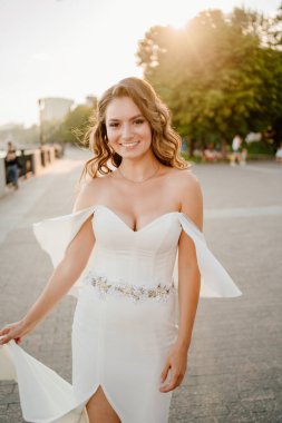 Güneş parlaması. Uzun bukleli beyaz elbiseli gelin.