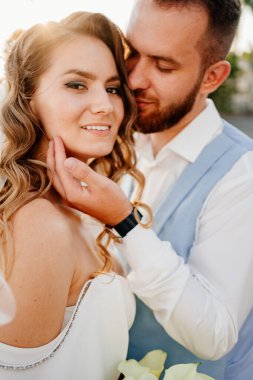 Güneş parlaması. Uzun bukleli, beyaz, zarif elbiseli, zambaklı gelin..