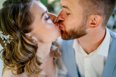 Yakın plan. Yeni evliler öpüşüyor. Mutlu ve güzel gelin ve damat