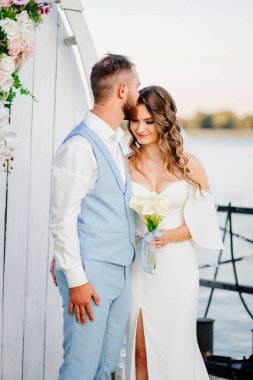 Rıhtımda suyun kenarında güzel bir düğün töreni. gelin ve damat.