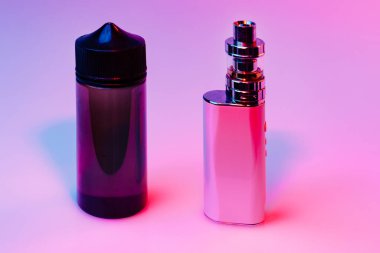 Solumak için bir şişe sıvı ve elektrikli puro. Renkli ışıkta