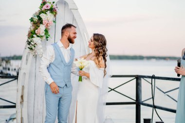 Rıhtımda suyun kenarında güzel bir düğün töreni. gelin ve damat.